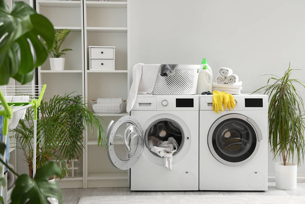 Интерьер прачечной со стиральными машинами и чистящими средствами - Фото, изображение