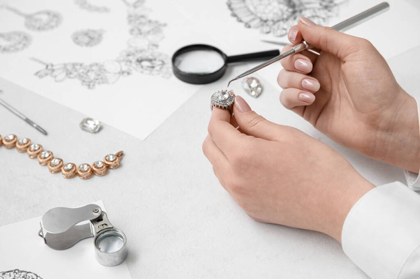 Female jeweler making ring on white table, closeup - Photo, Image