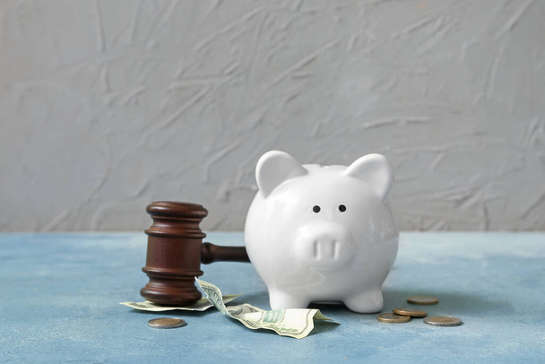 Piggy bank with judge gavel and money on grunge blue background. Concept of bankruptcy - Foto, Imagen