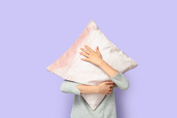 Γυναίκα με μαξιλάρι κοντά στον λιλά τοίχο - Φωτογραφία, εικόνα