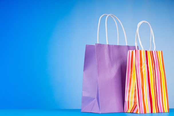 Colourful paper shopping bags against gradient background - Fotó, kép