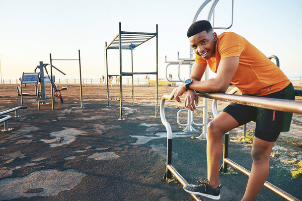 Ive been spending a lot more time being active. a young man working out at the outdoor gym at the park - Foto, afbeelding