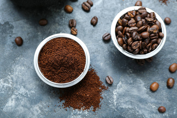 Bowls with coffee beans and powder on dark background - Fotoğraf, Görsel