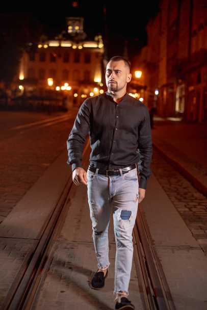 male businessman in black shirt in night city under street light - Photo, image