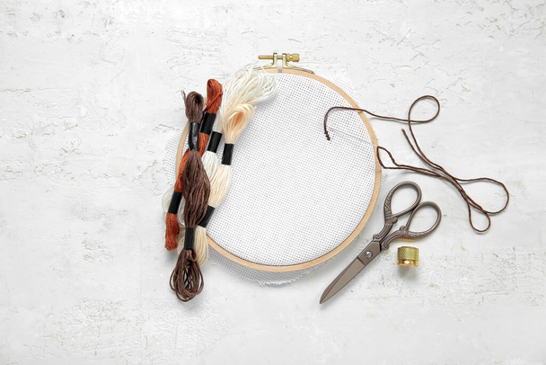 Dřevěný vyšívací obruč s nůžkami, plísňovými nitěmi a náprstkem na grunge bílém pozadí - Fotografie, Obrázek