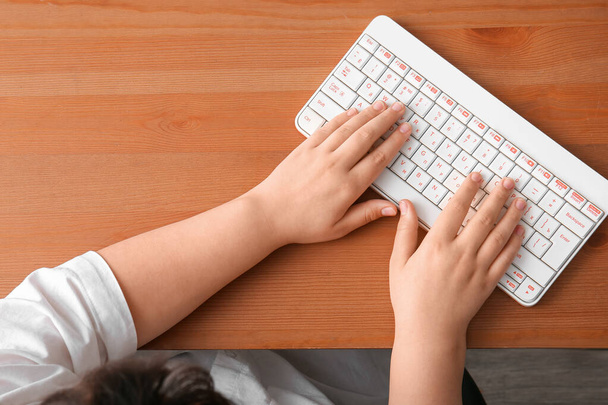 Programador femenino usando teclado de computadora en mesa de madera - Foto, Imagen