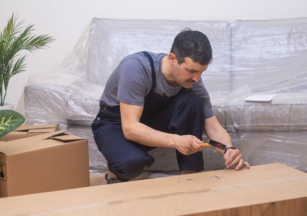 Puusepäntyöt liikemies luoda mukautettuja huonekaluja laadukkaita puumateriaaleja toimisto- ja kodin sisätilat tehtaan asiantuntija takomalla naula puinen vaatekaappi - Valokuva, kuva