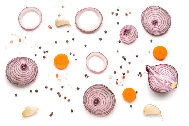Composición con rodajas de cebolla fresca, zanahoria y especias sobre fondo blanco - Foto, Imagen