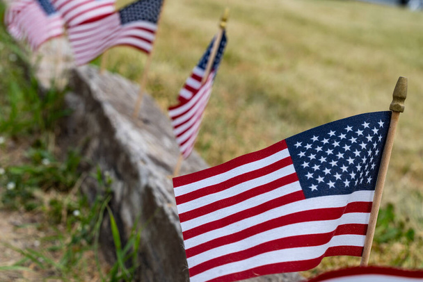 Μικρές αμερικανικές σημαίες σε κράσπεδο, για την Ημέρα της Σημαίας στις ΗΠΑ - 14 Ιουνίου. Επιλεκτική εστίαση - Φωτογραφία, εικόνα