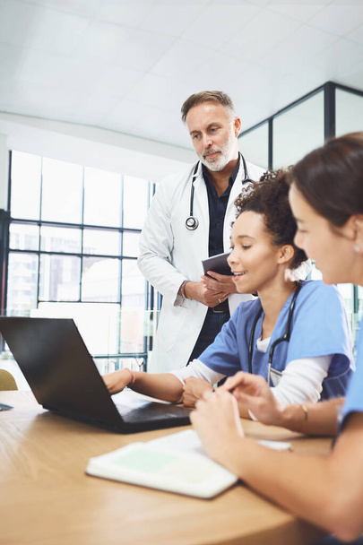 Nézzünk utána még egyszer. egy csapat orvos, akik laptopot használnak egy kórházban tartott megbeszélés során. - Fotó, kép