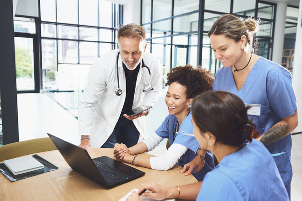 Az egész szakértői csapat rajta van. egy csapat orvos, akik laptopot használnak egy kórházban tartott megbeszélés során. - Fotó, kép