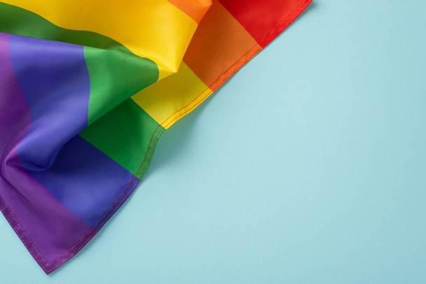 Świętowanie Miesiąca Historii LGBT z płaskim widokiem na szczyt tęczowej flagi parady na pastelowym niebieskim tle z miejscem na tekst - Zdjęcie, obraz