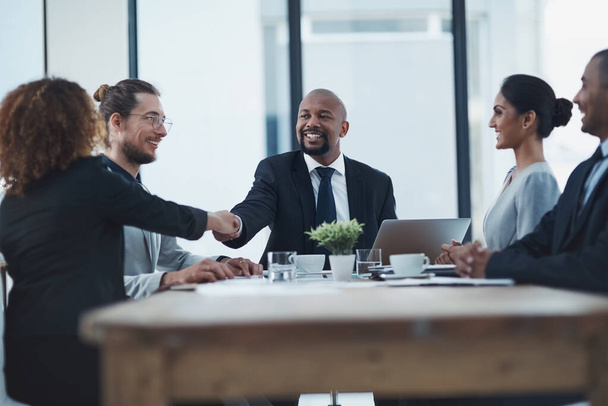 成功したい場合はチームワークが不可欠です。2人のビジネスマンがスタッフミーティングで握手をし - 写真・画像
