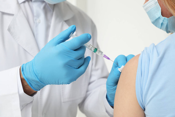Doctor giving hepatitis vaccine to patient on white background, closeup - Foto, imagen