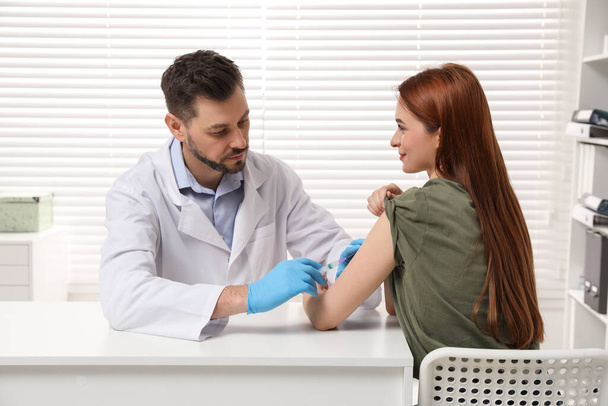 Doctor giving hepatitis vaccine to patient in clinic - Fotografie, Obrázek