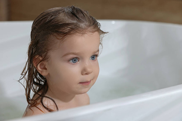Cute little girl washing hair with shampoo in bathroom. Space for text - Fotoğraf, Görsel