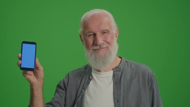 Écran vert. Portrait d'un vieil homme souriant avec un smartphone à écran bleu. Technologies émergentes pour les aînés.Maisons jumelées et Internet des objets pour les aînés. - Séquence, vidéo