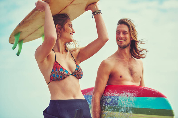 Salir con un surfista es muy divertido. una joven pareja caminando por la playa con sus tablas de surf - Foto, Imagen