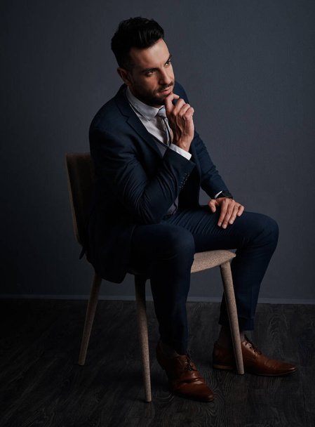 Planning his next move with precision. Studio shot of a stylish young businessman looking thoughtful against a gray background - Foto, Imagen