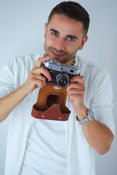 Young man with camera. Isolated over white background - Φωτογραφία, εικόνα