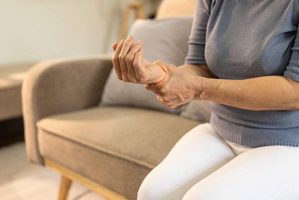 Пациентка пожилого возраста страдает воспалительной болью в запястье, бериберией или периферической невропатией, пожилая женщина массирует руки болью в запястье - Фото, изображение