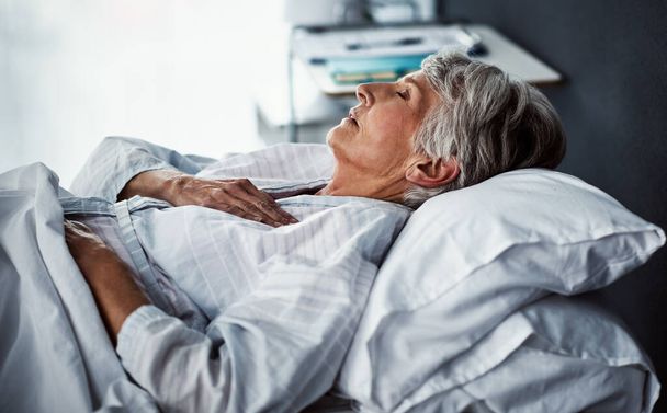 Ze heeft rust nodig. een zieke oudere vrouw liggend in een ziekenhuisbed - Foto, afbeelding
