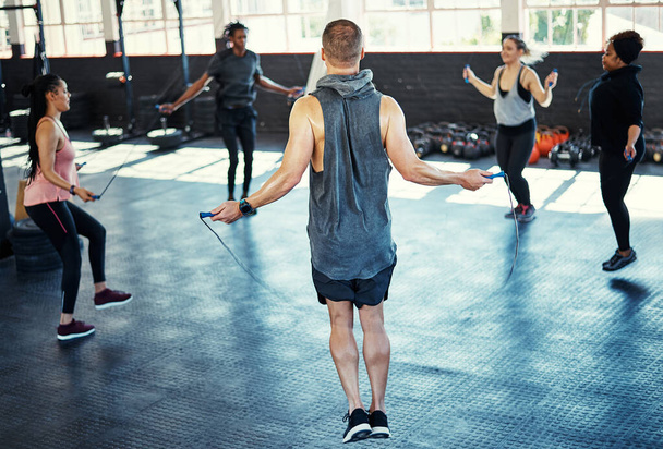 Puoi saltare tutto, ma non un allenamento. un gruppo di fitness che fa esercizi di corda nella loro sessione in palestra - Foto, immagini