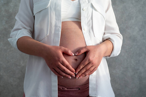 Raskaana olevan naisen vatsa. Raskauden käsite. Keskiosa muotokuva tunnistamaton nainen raskauden viimeisinä kuukausina - Valokuva, kuva