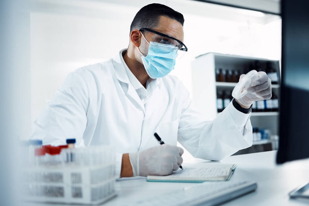 Laboratory, medical research and scientist writing notes while doing an analysis on virus data. Write, face mask and male science researcher working on scientific project at pharmaceutical lab - Fotografie, Obrázek