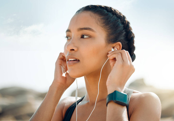 Γυναίκα με ακουστικά, γυμναστήριο στην παραλία και ακούγοντας μουσική για κίνητρο και προπόνηση σε εξωτερικούς χώρους. Άσκηση, υγεία και ευεξία, γυναίκα αθλήτρια streaming online με ραδιόφωνο και ήχο στη φύση. - Φωτογραφία, εικόνα