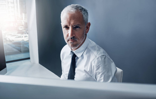 Cet homme d'affaires évolue avec le temps. un homme d'affaires concentré travaillant derrière son ordinateur dans le bureau - Photo, image