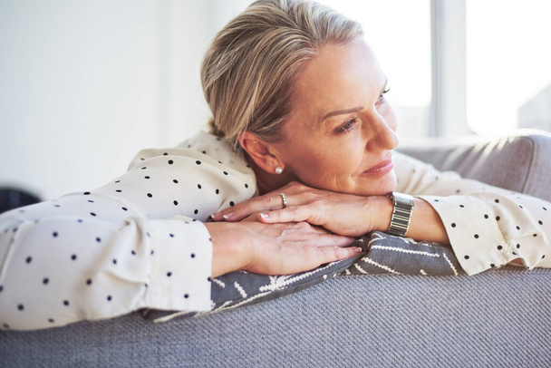 I so need this break. a happy mature woman relaxing on the sofa at home - Fotoğraf, Görsel
