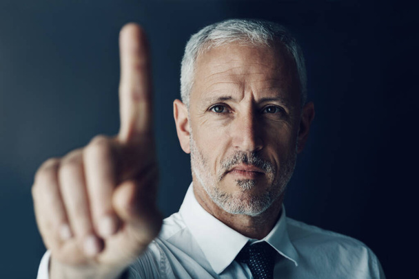 Auf dem Weg zum Erfolg. Porträt eines fokussierten Geschäftsmannes, der seinen Finger hochhält, als würde er einen Touchscreen im Büro benutzen - Foto, Bild