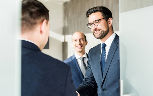 現代のオフィスでのビジネスミーティングで握手をして挨拶する自信のあるビジネスの人々のグループ。握手をすることによって契約を締結。ビジネスと起業家精神の成功コンセプト. - 写真・画像