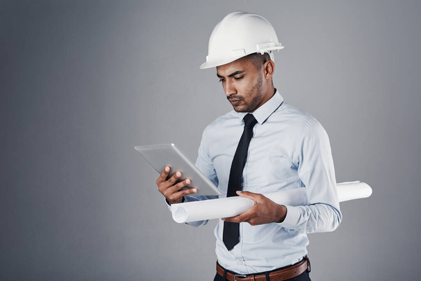 As ferramentas certas facilitam cada trabalho. um engenheiro civil bem vestido usando seu tablet enquanto estava no estúdio - Foto, Imagem