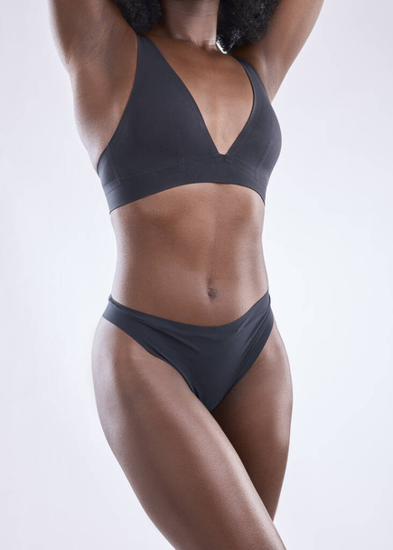 Lichaam, fitness en schoonheid met zwarte vrouw in studio voor voeding, gewichtsverlies en dieet. Gezondheid, welzijn en buikspieren met close-up van vrouwelijk model op witte achtergrond voor zelfverzorging en gloed. - Foto, afbeelding