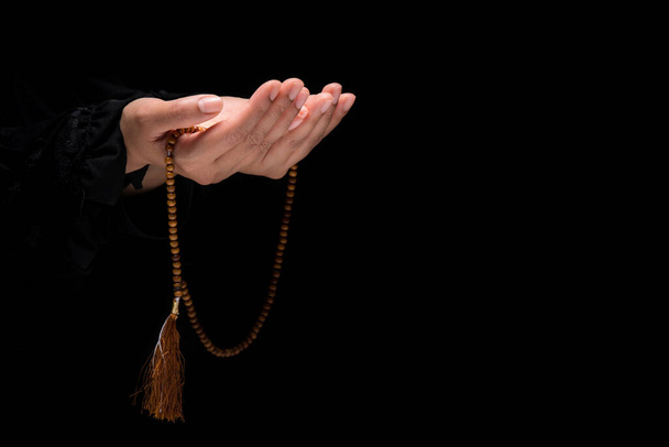 La imagen de la mano de una mujer musulmana, la oración islámica y su mano sosteniendo un rosario o tasbih. - Foto, imagen