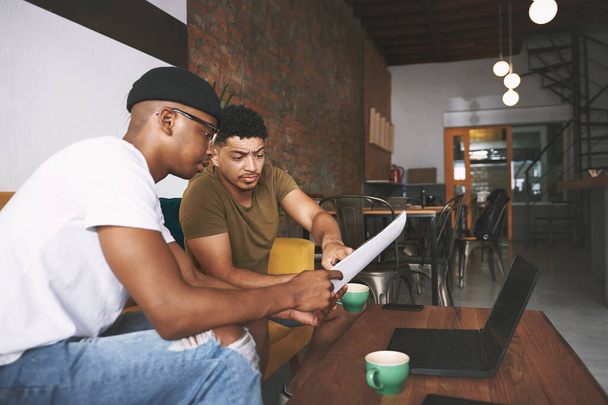 Работаем над бизнес-планом в нашем любимом кафе. двое молодых людей обсуждают бизнес, сидя вместе в кофейне - Фото, изображение