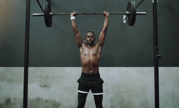 Weightlifting, fitness and black man with barbell in gym for training, exercise and intense workout. Deadlift, strong body and male body builder lifting weights for challenge, wellness and strength. - Zdjęcie, obraz
