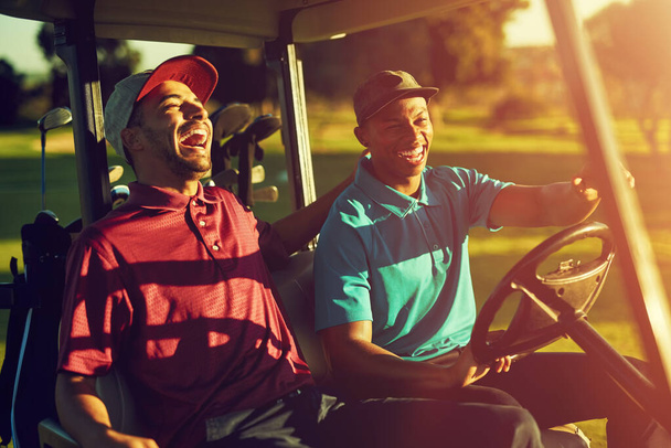 Έτσι θα κυλήσουμε. δύο παίκτες που οδηγούν σε ένα καρότσι σε ένα γήπεδο γκολφ - Φωτογραφία, εικόνα