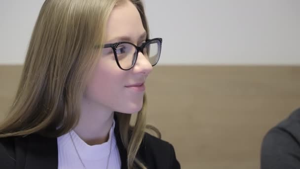 Gros plan d'une jeune femme en lunettes assise à une réunion et écoutant attentivement. Employé de bureau de l'entreprise - Séquence, vidéo