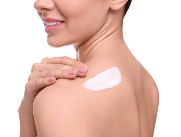 Woman with smear of body cream on her shoulder against white background, closeup - Foto, immagini