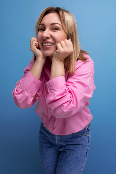 młoda ładna blondynka europejski pracownik biurowy kobieta z płynącymi włosami w różowej bluzce uśmiecha się słodko. - Zdjęcie, obraz