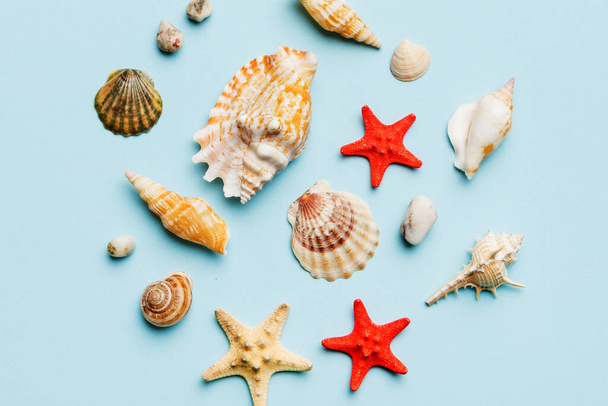 Concepto de hora de verano Composición plana con hermosas estrellas de mar y conchas de mar en la mesa de colores, vista superior. - Foto, imagen