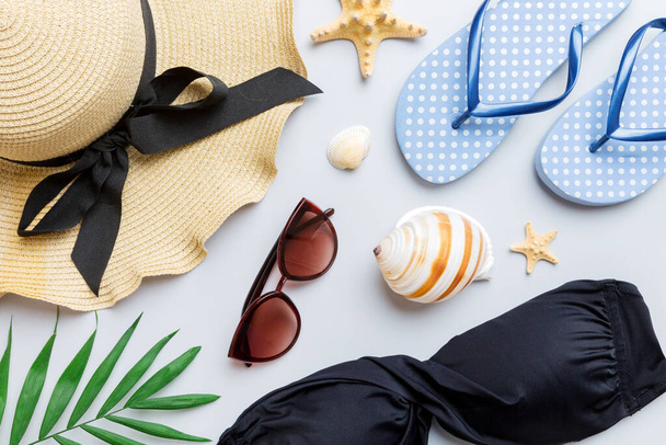 Woman swimwear and beach accessories flat lay top view on colored background Summer travel concept. bikini swimsuit, straw hat and seasheels. Copy space Top view. - Фото, изображение