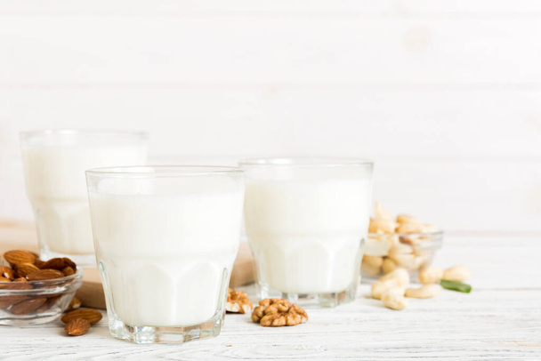 Set or collection of various vegan milk almond, cashew, on table background. Vegan plant based milk and ingredients, top view. - Fotografie, Obrázek