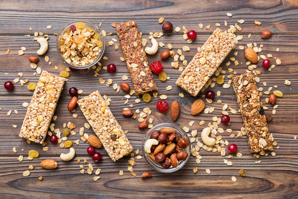 Various granola bars on table background. Cereal granola bars. Superfood breakfast bars with oats, nuts and berries, close up. Superfood concept. - Photo, Image