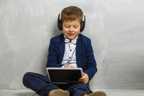 smiling schoolboy with digital tablet on gray. - Zdjęcie, obraz