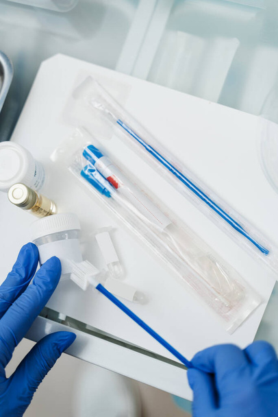 Il ginecologo tiene in mano una fiaschetta per il Pap test citologico. Citologia ginecologica Pap test striscio e citoscopio nelle mani del ginecologo - Foto, immagini