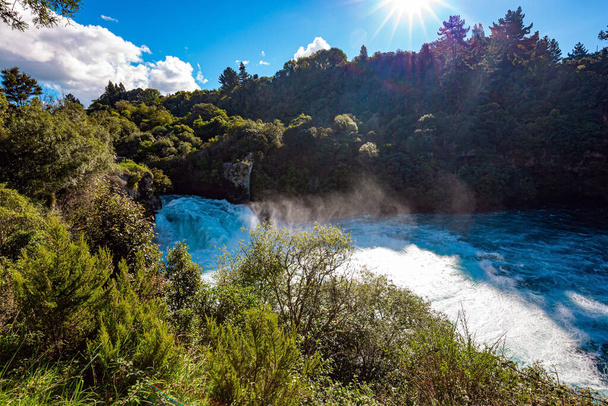 Snow-white foam flies over turquoise water. Rumbling and frothy waterfall of Huka Falls. Waikato River, North Island, New Zealand.  - Foto, Bild